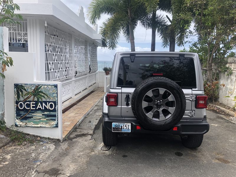 The silver Sahara parked at the Oceano property beside its mosaic sign