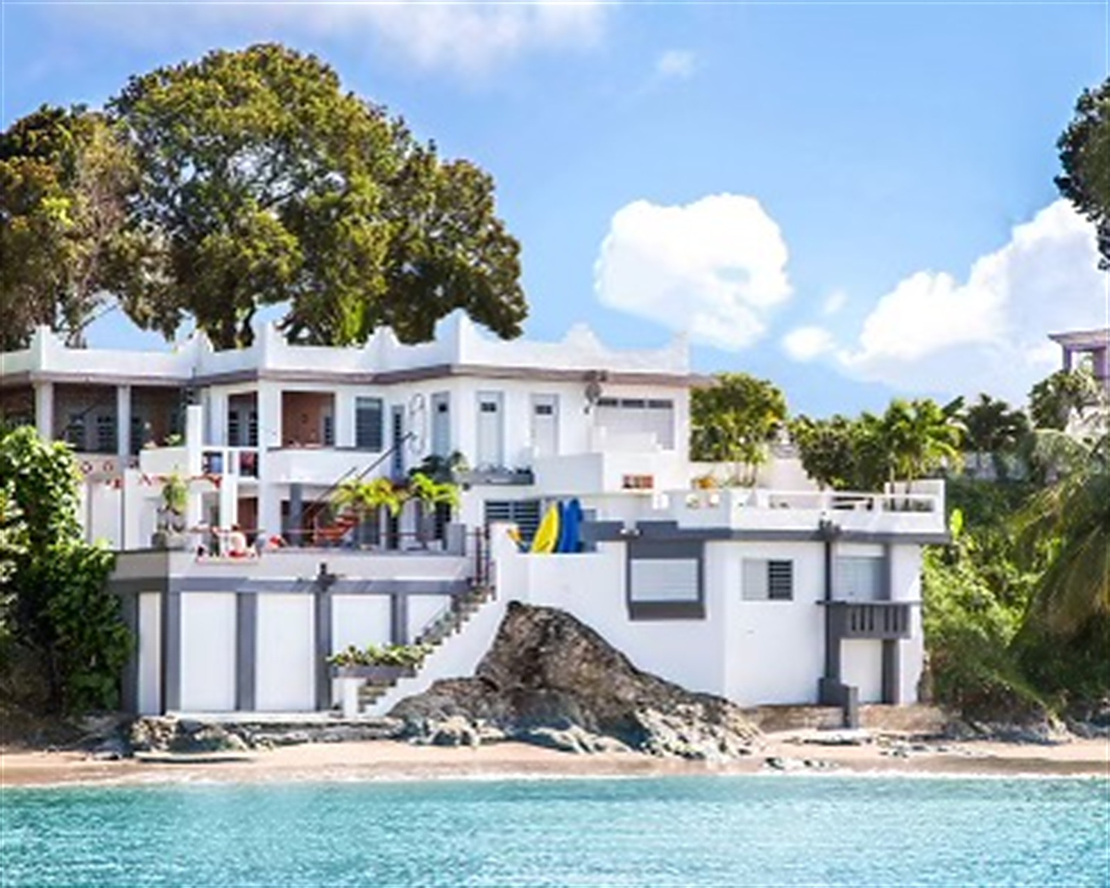 Oceano seen from the water: a white multi-level house on the rocks above a small beach