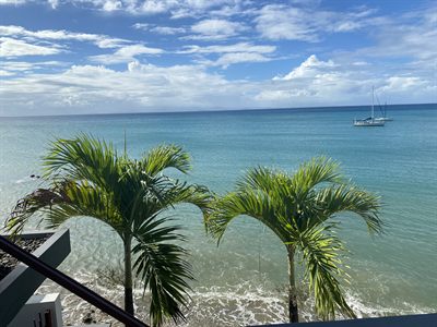 Looking down onto the terrace and its dining table, with the reef and open sea beyond