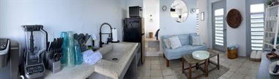 Wide view across the kitchen counter to the sofa and seating area