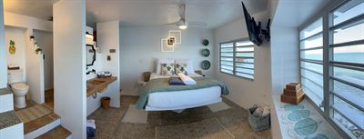 Panorama of a queen bedroom with its open ensuite, a hanging marlin sculpture on the wall