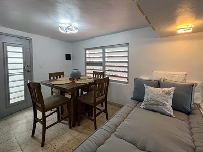 Wooden dining table and chairs next to a long cushioned daybed