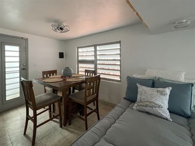 Dining table for four with the daybed alongside and louvered windows behind