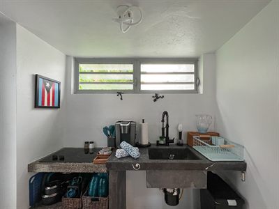 Concrete sink and counter in the kitchenette, with the Puerto Rican flag print above