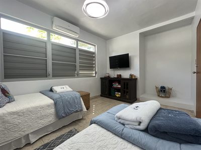Twin bedroom with matching single beds and a television on a dark console