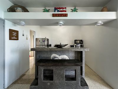 Kitchen with a stone breakfast bar, starfish decor and a painted Vieques sign above