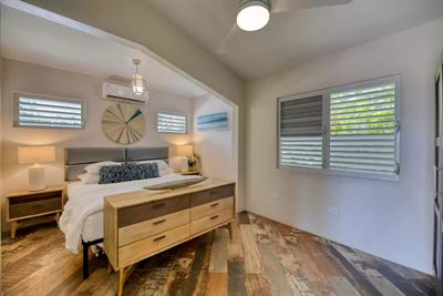 Wider view of the Media Luna bedroom, louvered windows on two sides and a ceiling fan overhead