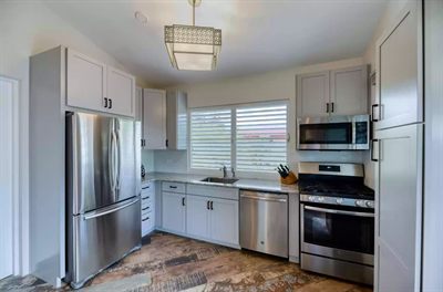 Media Luna kitchen with gray shaker cabinets, stainless appliances and a gas range