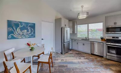 Media Luna kitchen and dining area, a round white table and an octopus painting on the far wall